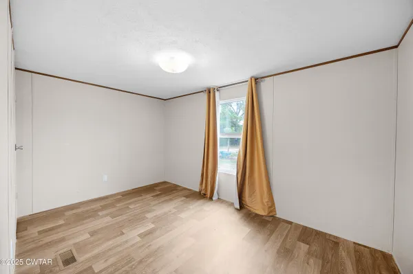 an empty room with wooden floor and a window