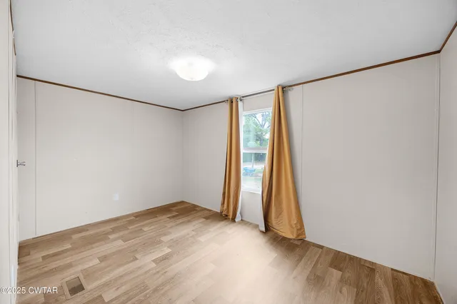 an empty room with wooden floor and a window