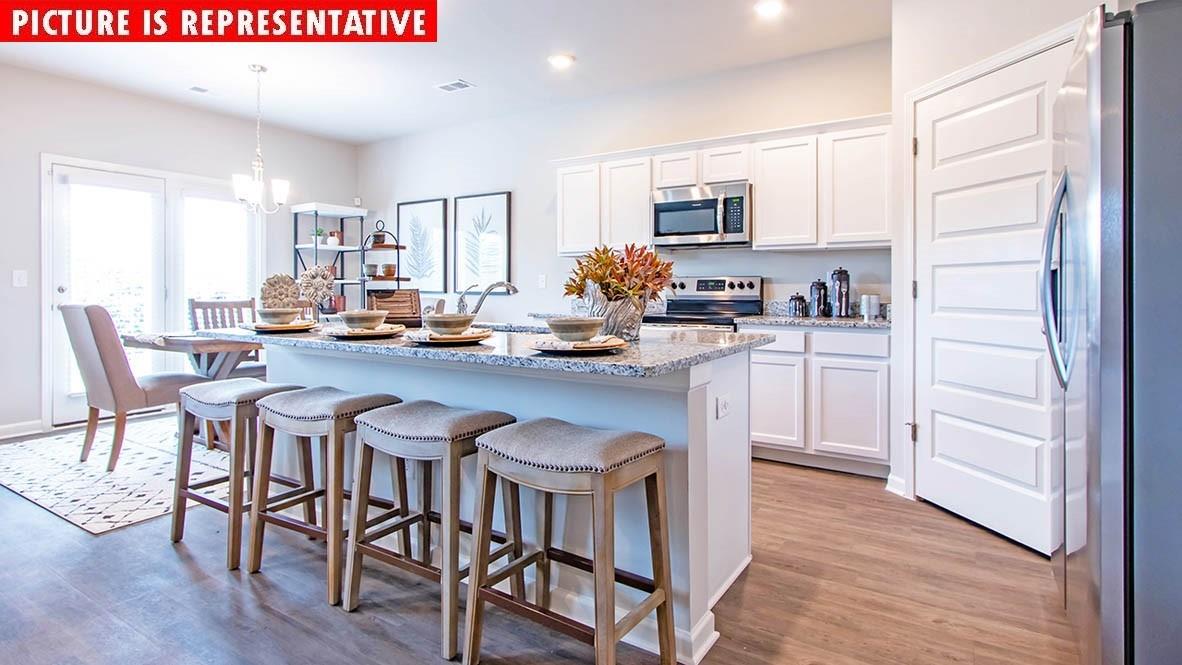 1204 Secrest Cmns Drive Monroe, NC 28112 - Photo 7 of 22 a kitchen with stainless steel appliances granite countertop a table chairs sink refrigerator and cabinets
