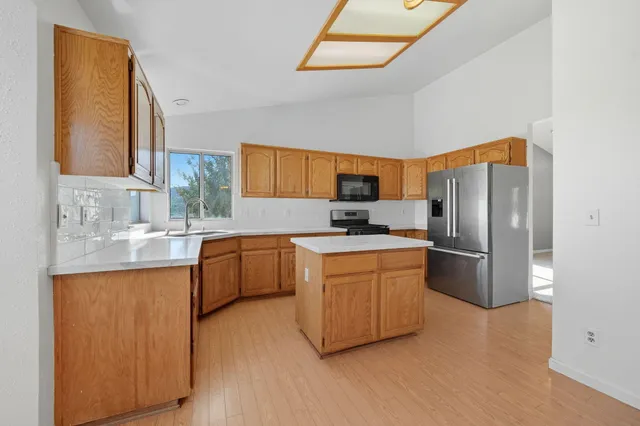 a kitchen with stainless steel appliances granite countertop a stove a sink and a microwave