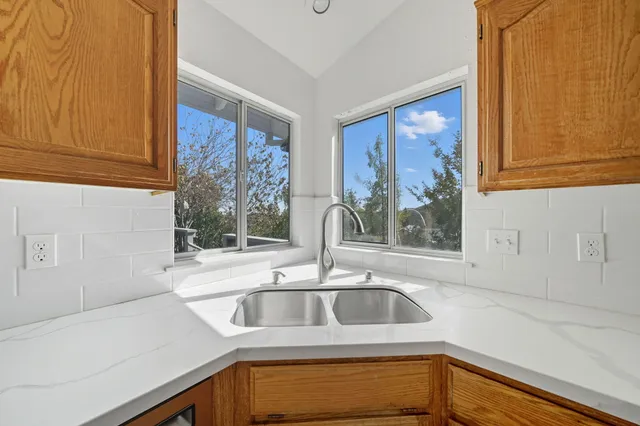 a kitchen with granite countertop white cabinets and black appliances