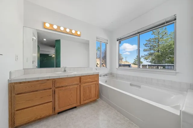 a bathroom with bathtub next to a window