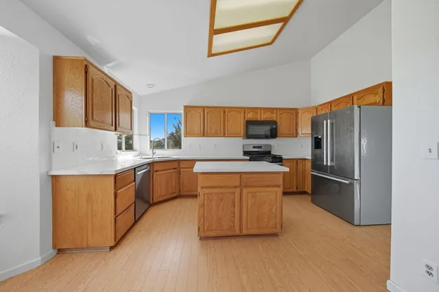 a kitchen with stainless steel appliances granite countertop a refrigerator and a stove top oven