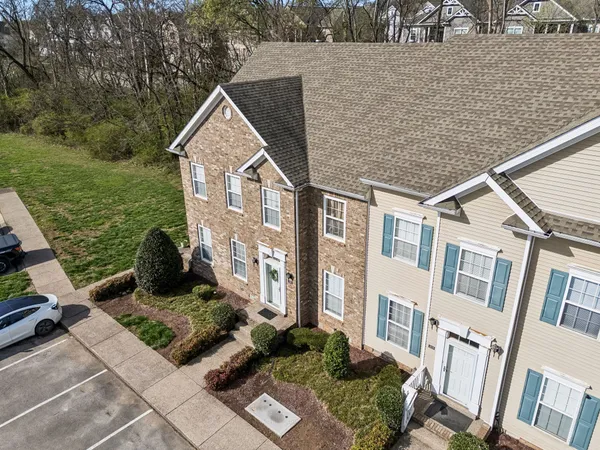 a view of a brick house next to a yard