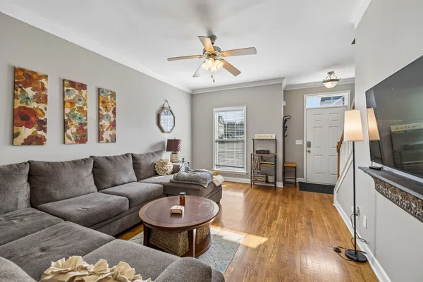 a living room with furniture and a wooden floor