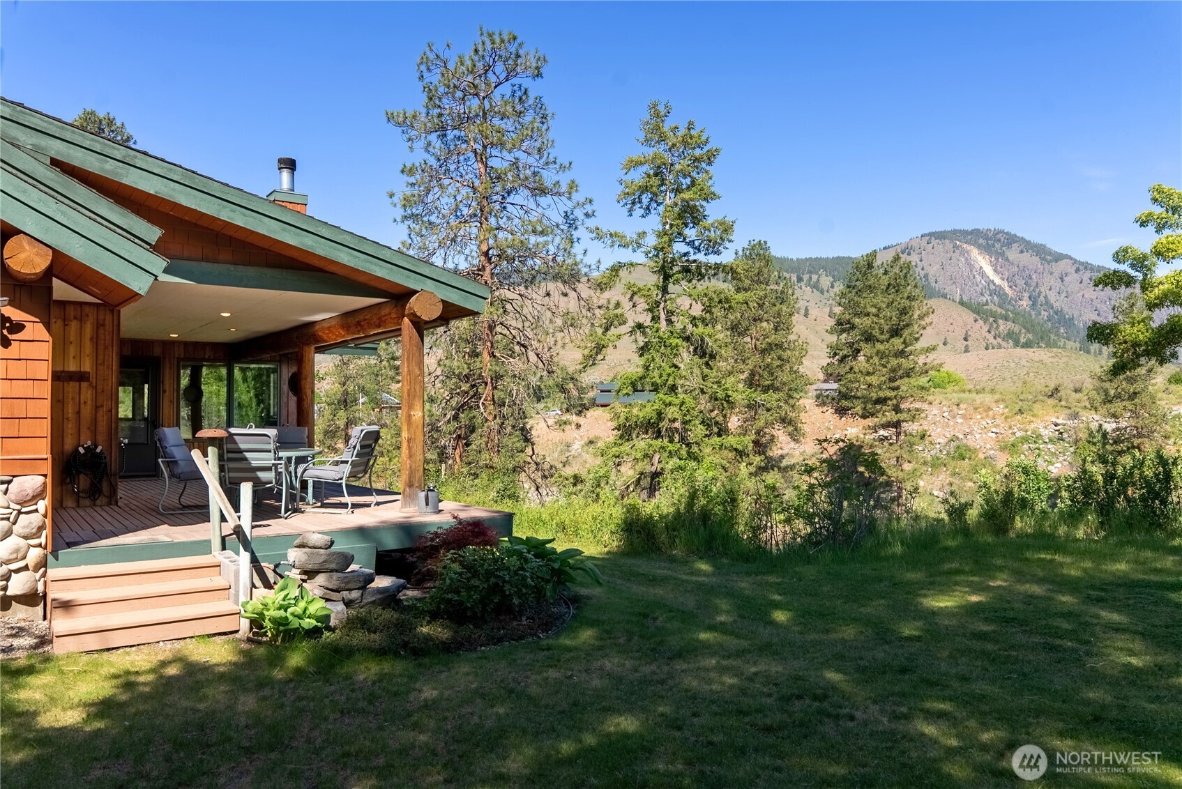 2621 Highway 153 Twisp, WA 98856 - Photo 34 of 40 a view of a patio with table and chairs potted plants with wooden floor and fence