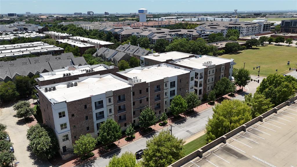 5015 Meridian Lane, Unit 2102 Addison, TX 75001 - Photo 34 of 36 Contemporary apartment building featuring brick and stone facades, private balconies, and landscaped grounds
