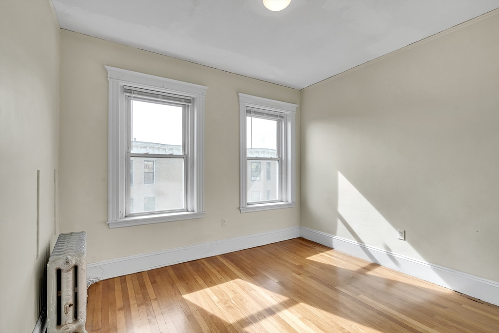 41 Orkney Road Boston, MA 02135 - Photo 27 of 28 a view of an empty room with wooden floor and a window