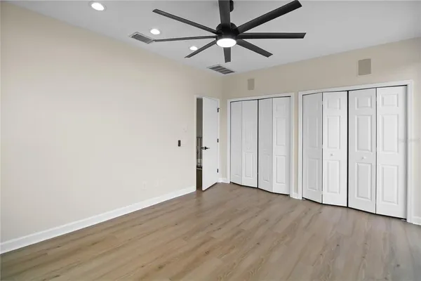 an empty room with a window and ceiling fan