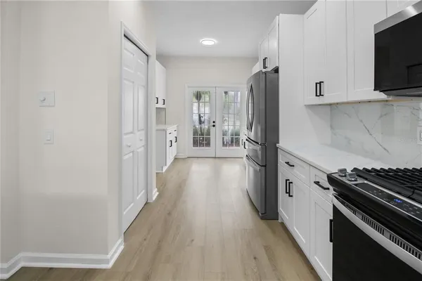 a kitchen with stainless steel appliances a refrigerator and a stove top oven