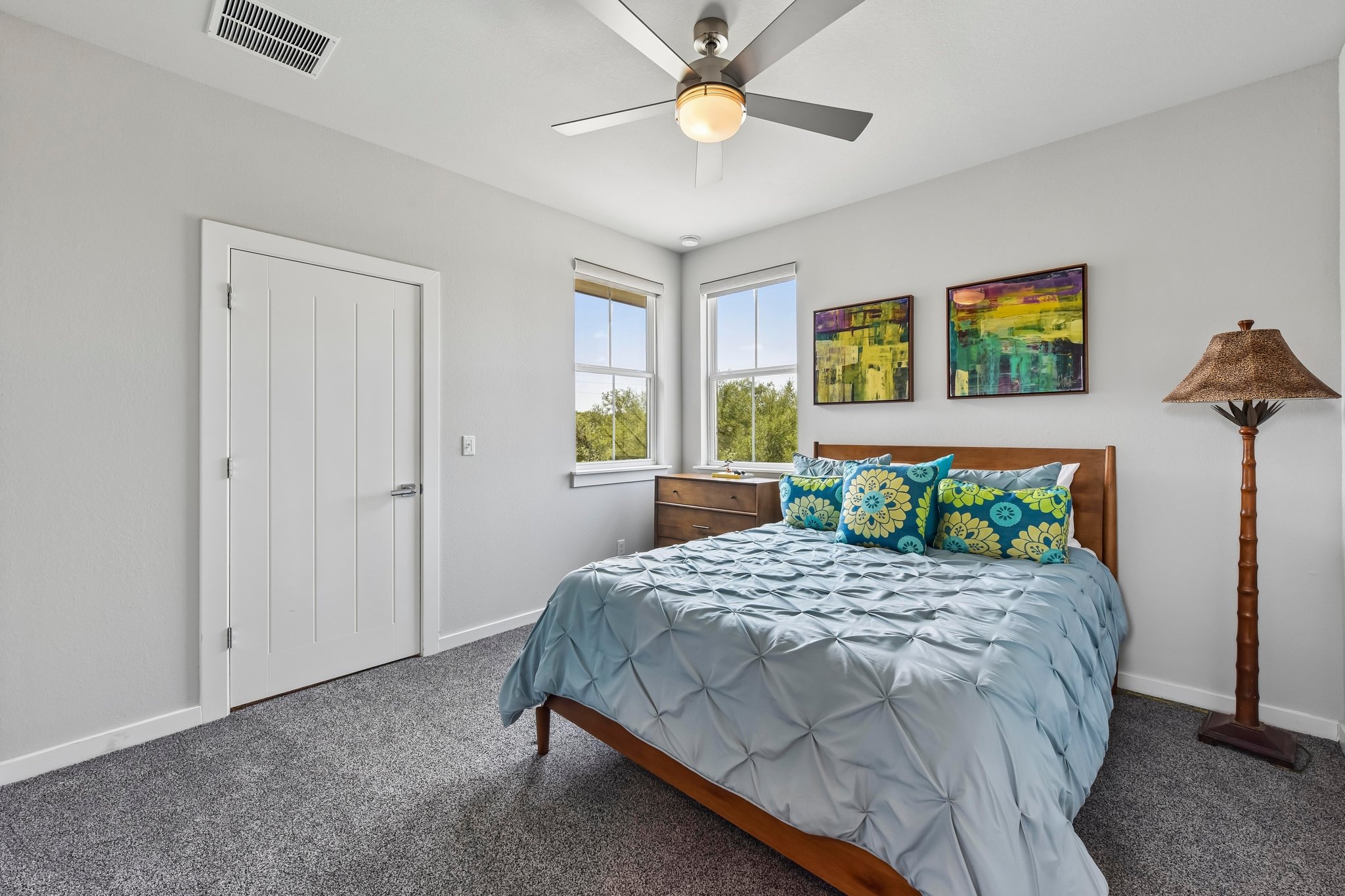 2203 Improver Road Spicewood, TX 78669 - Photo 20 of 38 A tranquil sleeping space featuring a comfortable bed and ample natural light through tall windows.
