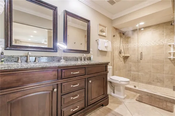 a bathroom with a granite countertop toilet sink and mirror