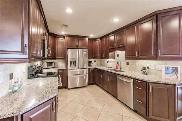 a kitchen with refrigerator cabinets and chairs