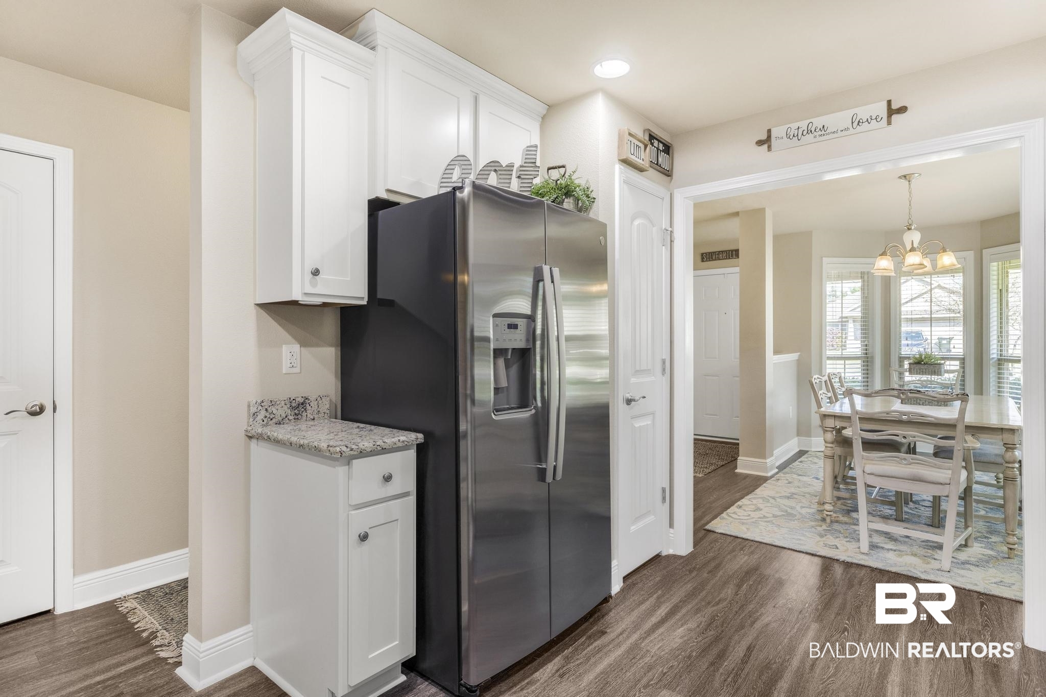 22043 Garland Loop Silverhill, AL 36576 - Photo 13 of 41 Kitchen featuring white cabinetry, stainless steel fridge with ice dispenser, dark wood finished floors, suspended lighting, and light stone countertops