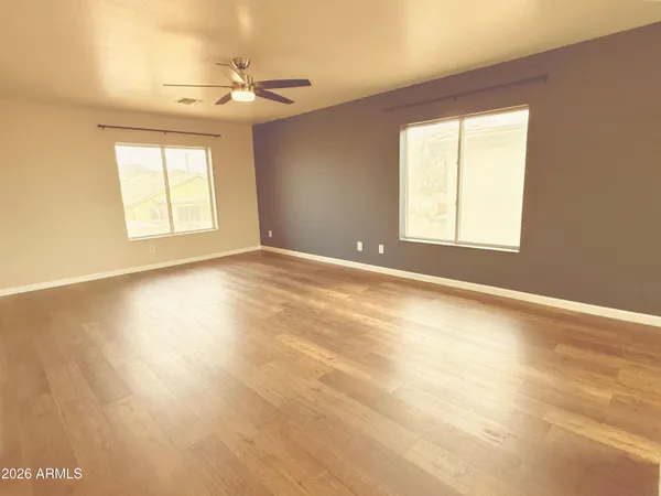 an empty room with windows and a ceiling fan