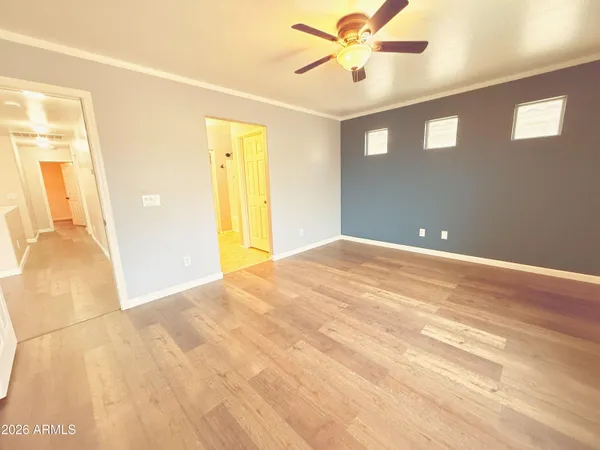 a view of a livingroom with wooden floor and a ceiling fan