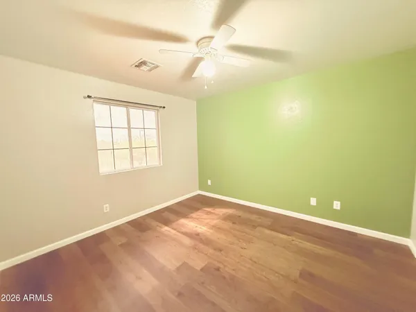 an empty room with windows and fan
