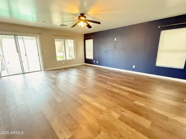 a view of an empty room with window and wooden floor
