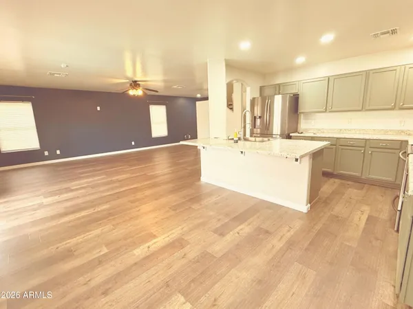 a large white kitchen with kitchen island a sink a stove and a cabinets