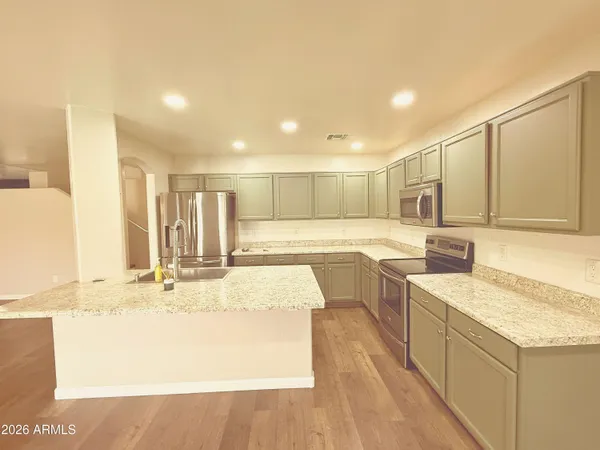 a large kitchen with kitchen island a sink stainless steel appliances and cabinets