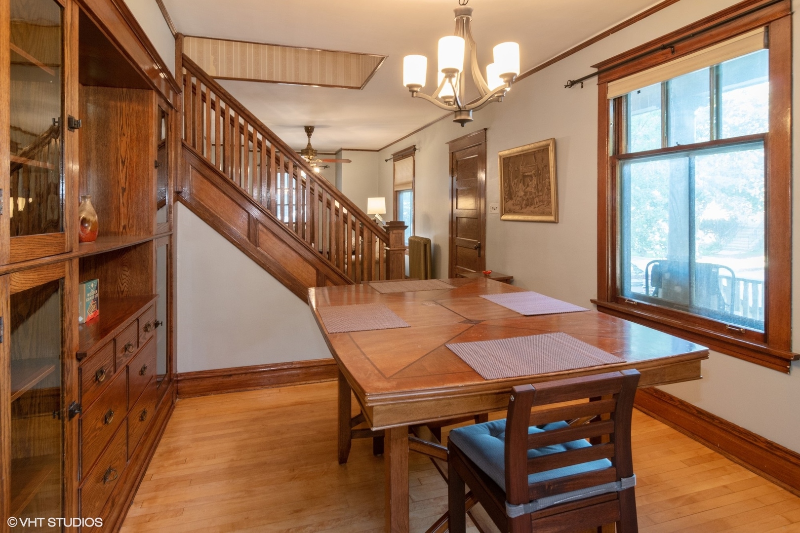 4132 Prairie Avenue Brookfield, IL 60513 - Photo 3 of 10 a dining room with wooden floor a chandelier a wooden table and chairs