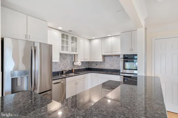a kitchen with stainless steel appliances granite countertop a refrigerator sink and stove