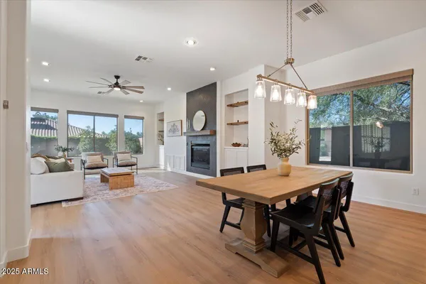 a view of a dining room and livingroom with furniture wooden floor a chandelier