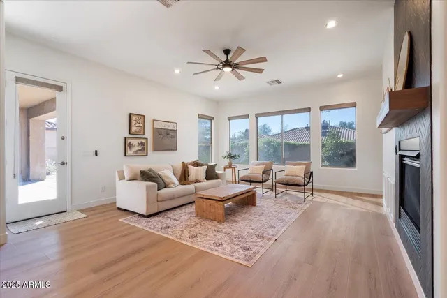 a living room with fireplace furniture and a large window