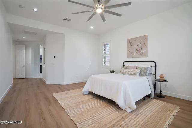 a bedroom with a large bed and a chandelier