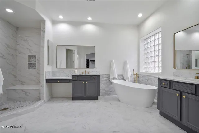 a large spacious bathroom with a granite countertop tub double vanity sink a mirror and a bathtub