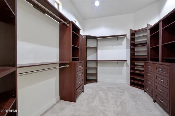 a view of walk in closet with clothes