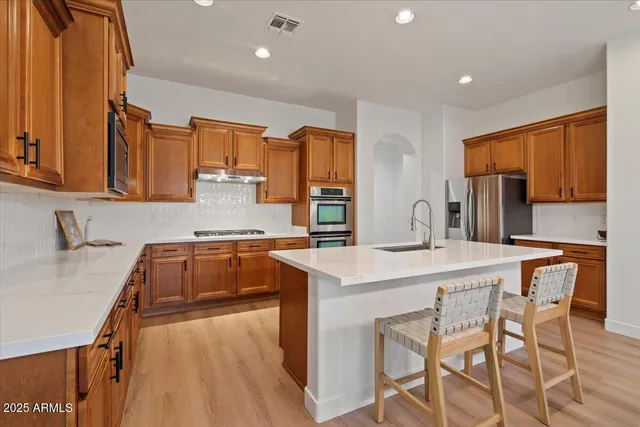 a kitchen with a sink a stove a refrigerator and cabinets