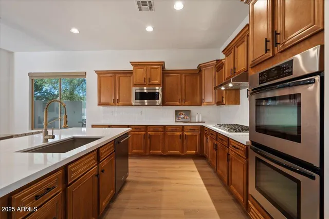 a kitchen with stainless steel appliances granite countertop a sink and stove top oven