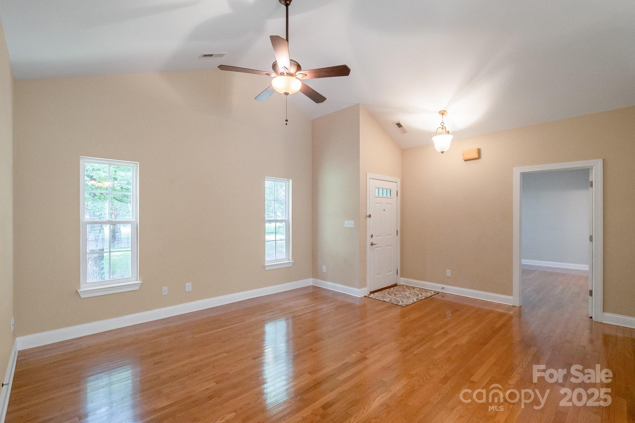 13221 Brandywine Lane Midland, NC 28107 - Photo 4 of 34 an empty room with wooden floor chandelier and window