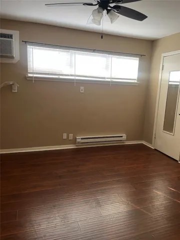 a view of a room with wooden floor and window