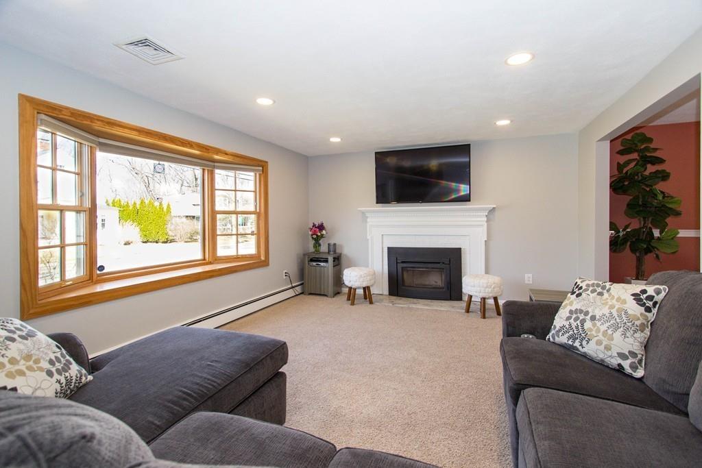 59 Warren Road Framingham, MA 01702 - Photo 3 of 25 a living room with furniture a flat screen tv and a fireplace
