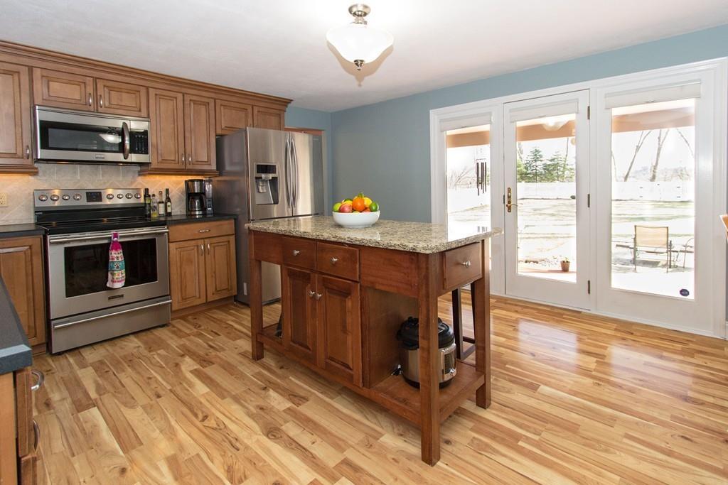 59 Warren Road Framingham, MA 01702 - Photo 6 of 25 a kitchen with stainless steel appliances granite countertop a stove a sink dishwasher and a microwave oven with white cabinets