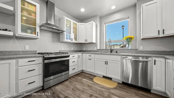 a kitchen with stainless steel appliances granite countertop a sink cabinets and wooden floor