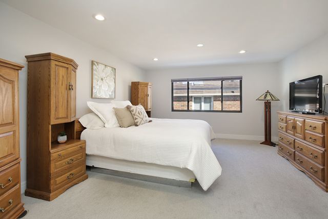 a spacious bedroom with a bed and a flat screen television