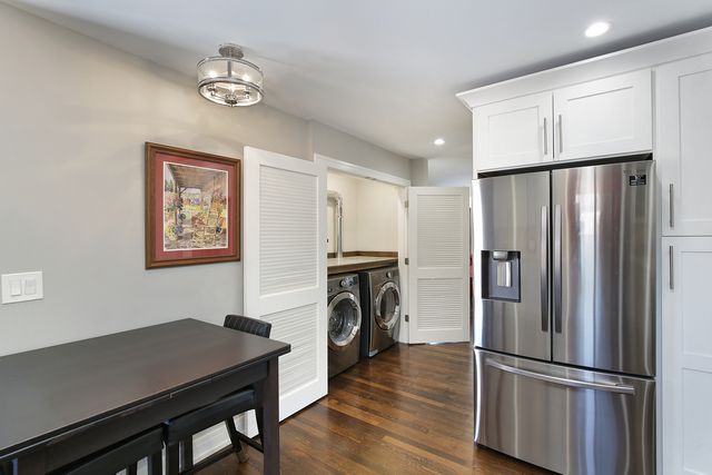a view of kitchen with furniture refrigerator and wooden floor