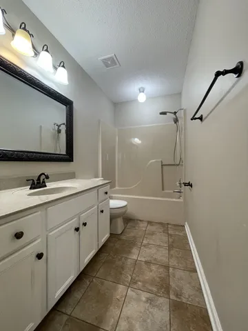 a bathroom with a double vanity sink mirror and toilet