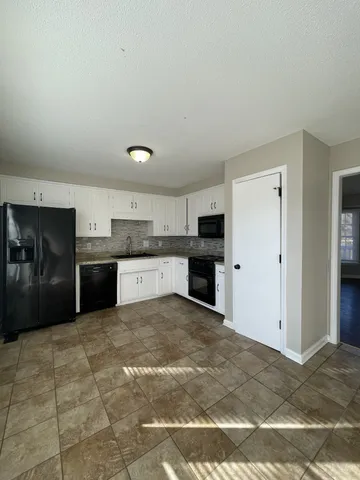 a view of a kitchen with granite countertop cabinets and refrigerator
