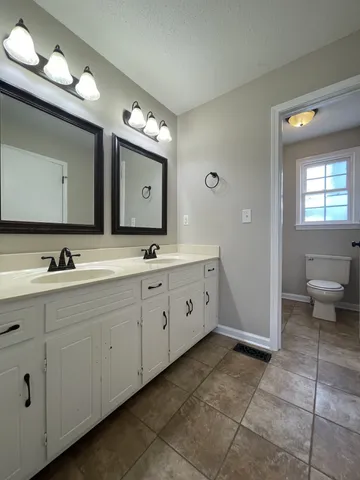 a spacious bathroom with a double vanity sink and a mirror