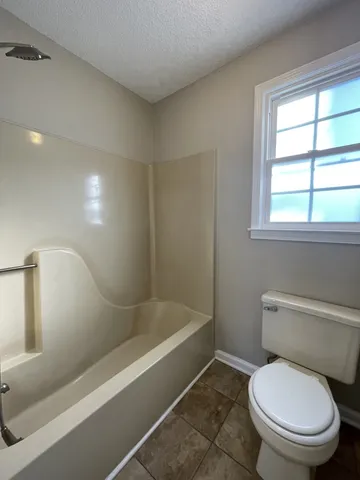 a white toilet sitting next to a bath tub