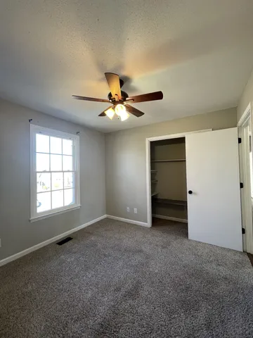 a view of an empty room with a ceiling fan