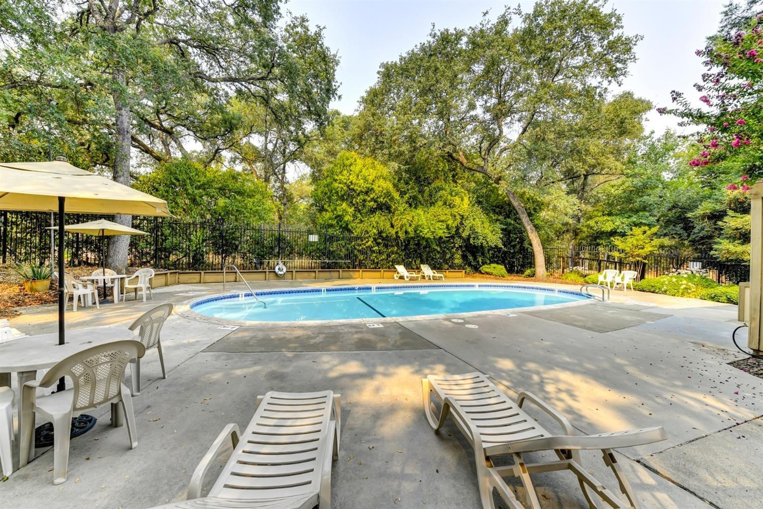 7025 Rancho Mirage Court Citrus Heights, CA 95621 - Photo 67 of 69 a view of a swimming pool with lawn chairs under an umbrella