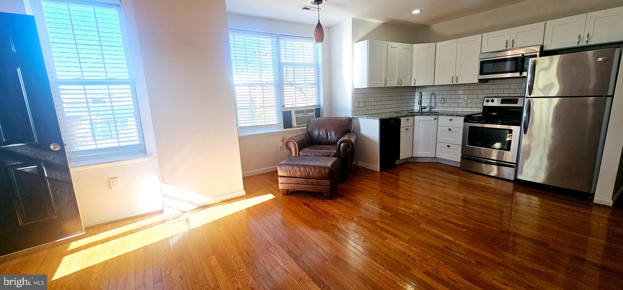 362 West Ritner Street, Unit 3 Philadelphia, PA 19148 - Photo 2 of 13 a kitchen with stainless steel appliances a refrigerator and wooden floor