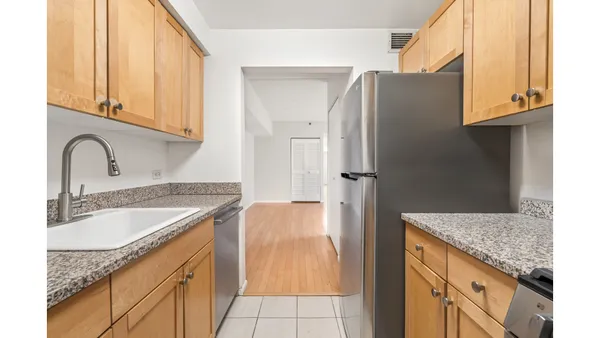 a kitchen with granite countertop a sink stainless steel appliances and cabinets