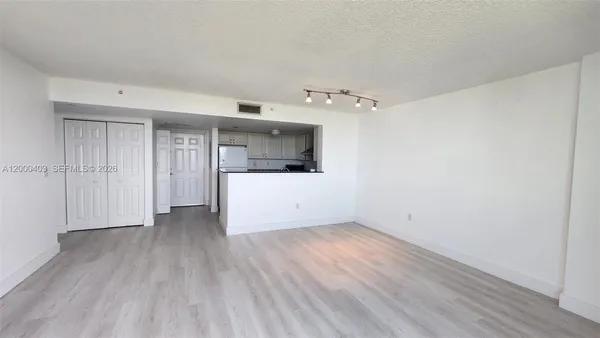 a view of a room with wooden floor and white walls