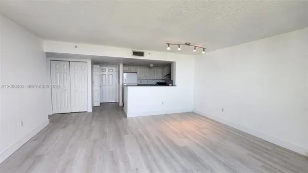 a view of a kitchen with a sink and a refrigerator